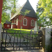 bild från ingången från staketgatan, röd träkyrka med svart pärttak
