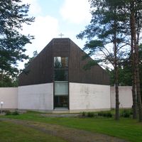 Sideby kyrka utifrån. Man ser det höga altarförstret. Kyrkan liknar fören på en båt, underdelen vit och övre delen svart